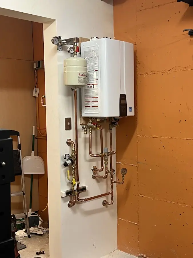 Plumbing technician inspecting water heater connections in Morristown